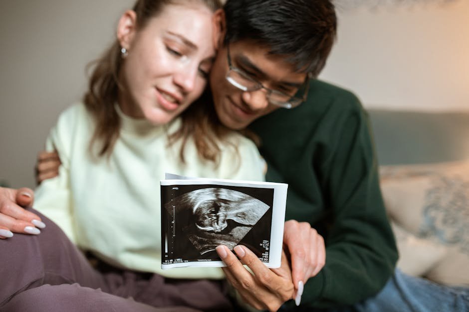 A happy couple embracing while looking at an ultrasound image of their future baby.